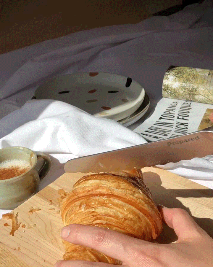 the bread knife cutting a croissant very smoothly in half