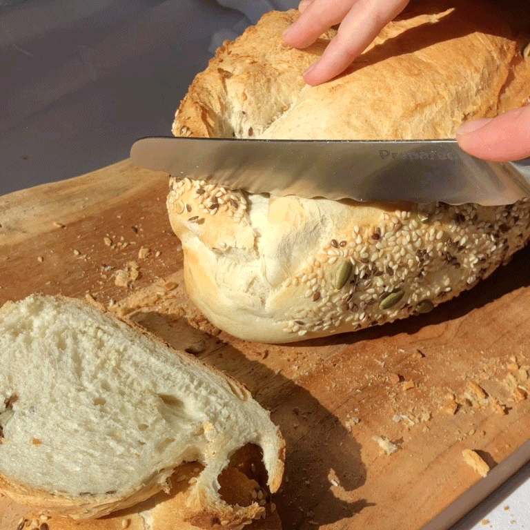 Bread knife cutting through a multi grain loaf
