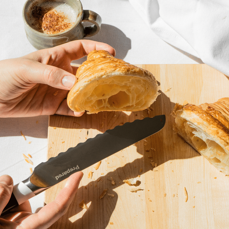 Holding the perfectly sliced, light and airy croissant, while holding the bread knife in the other hand