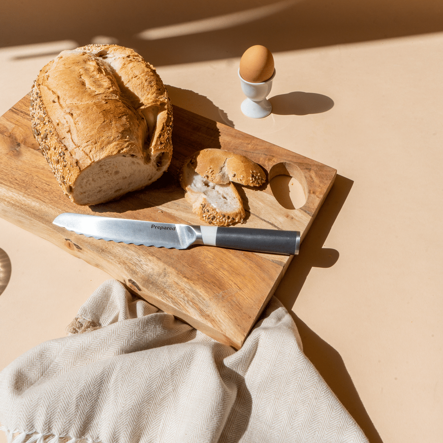 Prepared Serrated,, Bread Knife in color Ash on cutting board, egg and bread